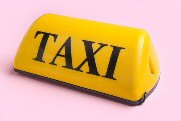 Yellow taxi roof sign on pink background