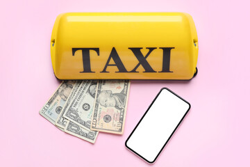 Yellow taxi roof sign, dollar banknotes and smartphone on pink background