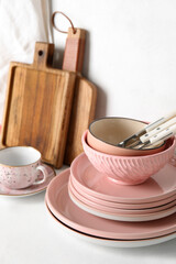 Set of different dishware and kitchenware on white table