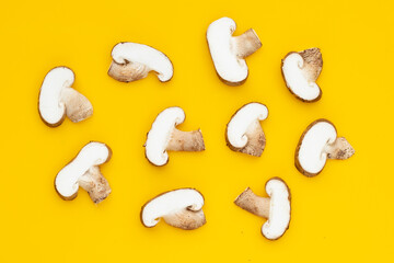 Fresh shiitake mushrooms on yellow background.