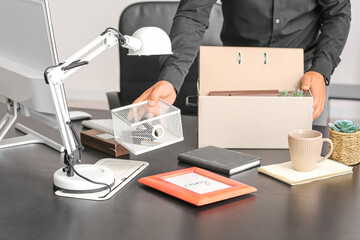 Fired young man packing his stuff in office