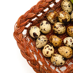 Wicker basket with fresh quail eggs isolated on white background, closeup