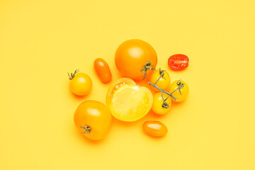 Heap of fresh yellow tomatoes on color background