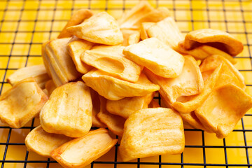 Jackfruit chips on yellow background.