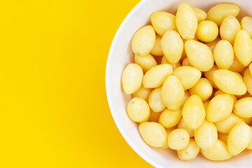Boiled ginkgo nuts on yellow background.