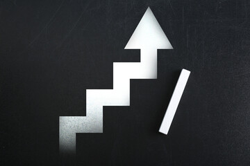 Stairs with up arrow drawn on chalkboard, top view. Steps to success