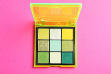 Colorful eyeshadow palette on pink background, top view