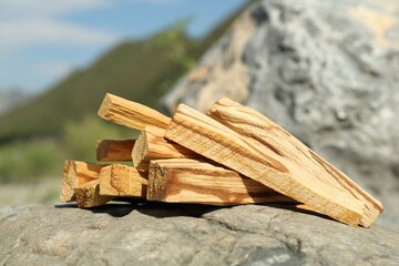 Many palo santo sticks on stone surface in high mountains, closeup