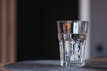 Glass of water on table against blurred background. Space for text