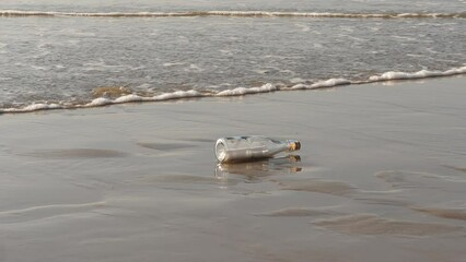 A message in a bottle washed up on the beach by waves