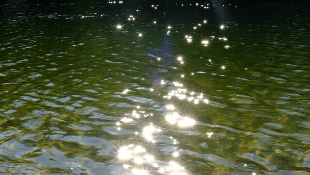 Defocus Ripples and sun glare on waves water. Blur water background. The flare from the sun on the waves. Fairy mood