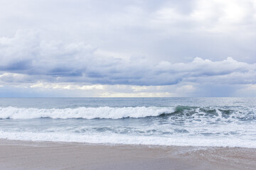 Fototapeta na wymiar Big sea waves crashing on sandy beach