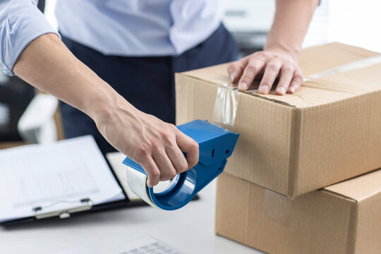 Small business owner packing boxes in office