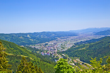 Fototapeta na wymiar Scene of Echigo Yuzawa city and mountain ranges in summer, views from Yuzawa Kogen.