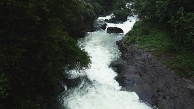 Waterfall Gorge with rocky vaults covered with lush foliage plants nearby beautiful Kerala waterfall in tropical forest on Idukki India.