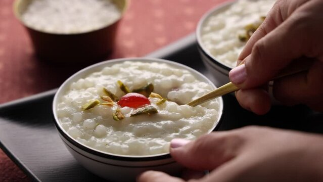 Sabudana Kheer thick pudding with tapioca pearls sago dessert from cassava root Indian sweet mithai chowari payasam for Mahashivratri Ram Navami Diwali festival 4k video footage