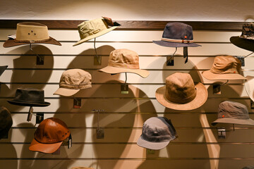 Sommerhüte und Hüte hängend an der Wand und warten auf den Verkauf in eim Hutgeschäft in Bozen,...