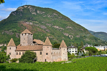 Fototapeta na wymiar Schloss Maretsch / Castel Mareccio mit Apfelplantage und Hörtenberg im Hintergund bei blauem Himmel in Bozen, Südtirol, Italien