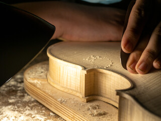 violin artisan maker hand smooth surfaces with scraper to desired plate thickness