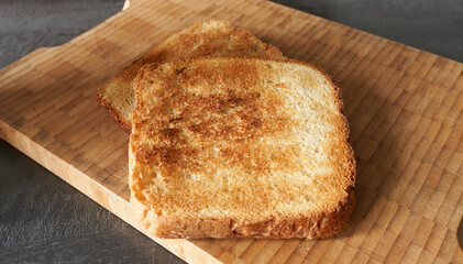 Fried toast on a wooden background, close-up. The concept is an example of carbohydrate food.