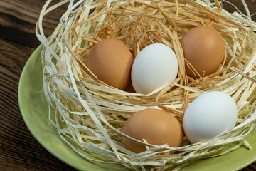 Brown and white eggs in a straw nest