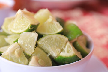 Natural fresh lime with water drops and sliced, on a white bowl