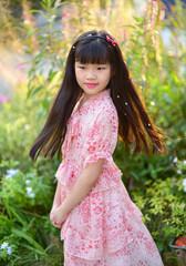 Portrait of a beautiful Asian girl 9 years old with long hair in garden
