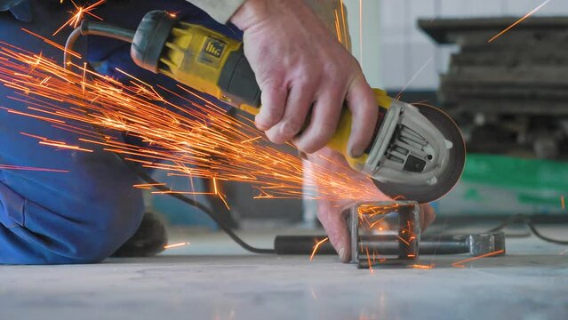 Man cutting metal with circular saw. Spark from hot iron. Hands and electric saw, hand tool. Hard work.