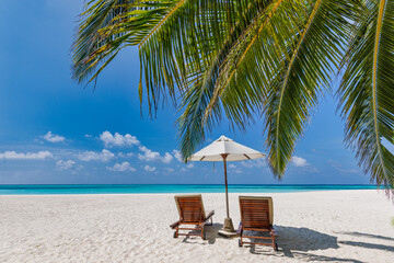 Obraz premium Beautiful panoramic nature. Tropical beach sunny as summer island landscape with chairs umbrella palm leaves calm sea shore, coast. Luxury travel panoramic destination banner for vacation or holiday