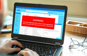Email attachments warning message on a laptop screen. Computer Virus and Antivirus.