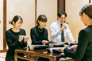 笑顔で食事する遺族（法事・お葬式・一周忌）
