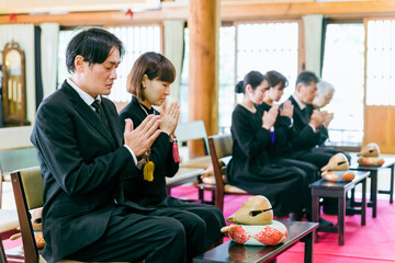 お葬式に参列する遺族（合掌）
