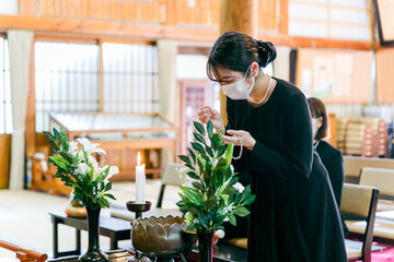 お葬式でお焼香する喪服姿の女性
