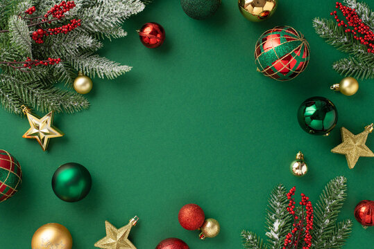 Christmas Tree Decorations Concept. Top View Photo Of Red Gold Green Baubles Star Ornaments Mistletoe Berries And Pine Branches In Hoarfrost On Isolated Green Background With Copyspace In The Middle