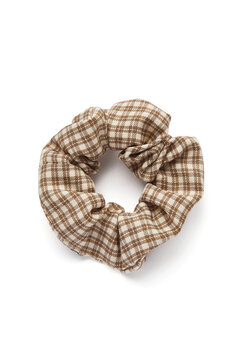 Subject shot of a wide plaid scrunchie made out of soft a silky fabric with checkered print. The rubber band is isolated on the white background. Vogue accessory for ladies and girls.