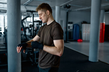 A boxer wrapping hand with bandage