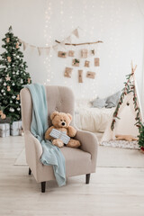 New year 2023 scandinavian interior. children's tent decorated with spruce branches, cozy armchair...