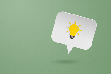 bright lightbulb  on white speech bubble paper cut on grunge green background including copy space