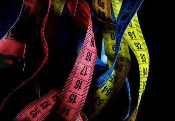 colorful measuring tapes on a black background