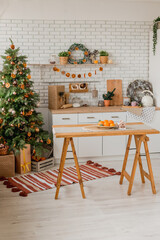 New year 2023 American kitchen interior. Christmas tree decorated with pieces of dried oranges, Wreath above the table, natural colors, organic living. selective focus