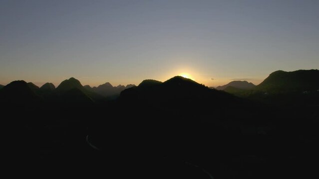Aerial slow movement around mountain landscape during sunset