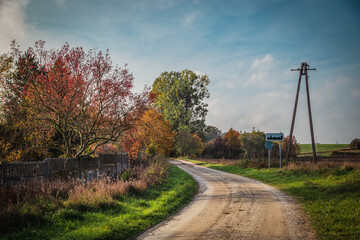 Jesienna droga ze znakiem "obszar zamieszkany". 
