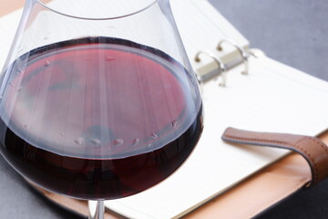 赤ワインを飲みながらリング式のシステム手帳でプランを立てる