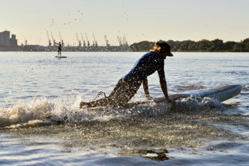 Man doing beach start on SUP on rowing competitions from stand up paddle boarding. River beach start on SUP