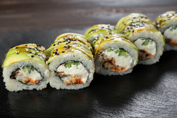 Sushi rolls japanese food over black background. Sushi roll with salmon, cream cheese and avocado. Japan restaurant menu.