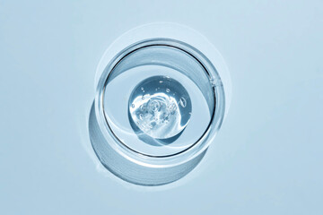 Top view of cosmetics gel with bubbles structure in the petri dish on blue background. ransparent cosmetic liquid or face serum, Transparent cosmetic gel Swatch