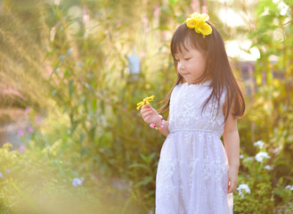 backlight Outdoor portrait of a cute 5 year old Asia little girl 