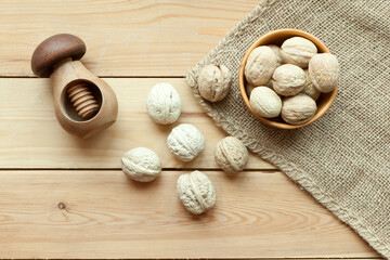 Fototapeta na wymiar walnuts group top view on wooden table with nutcracker. Walnut kernels and whole walnuts