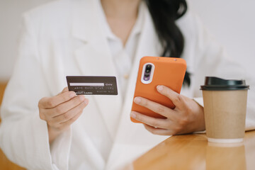 Happy asian Business woman pay online using mobile phone at the office.