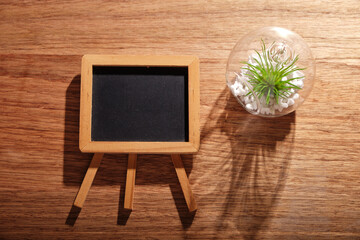 small blackboard with succulent plant on wood  table top